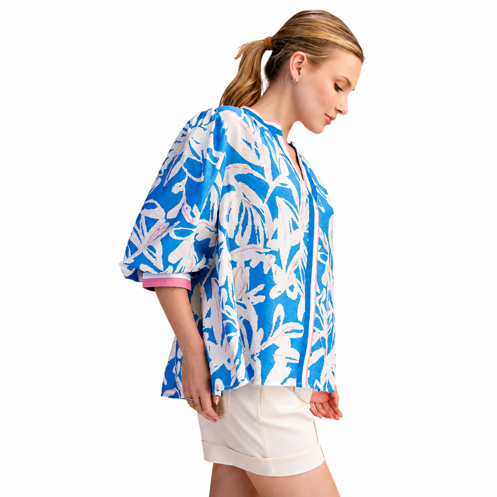 Woman wearing a blue and white floral blouse on a white background