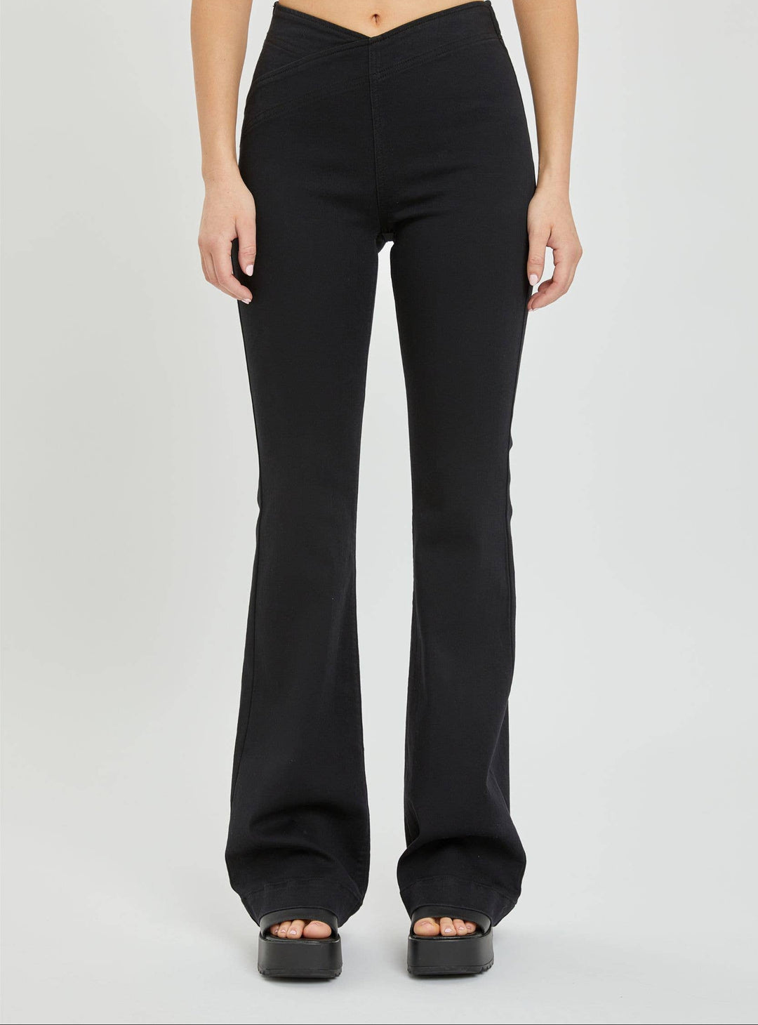 Black flared pants worn by a person on a white background