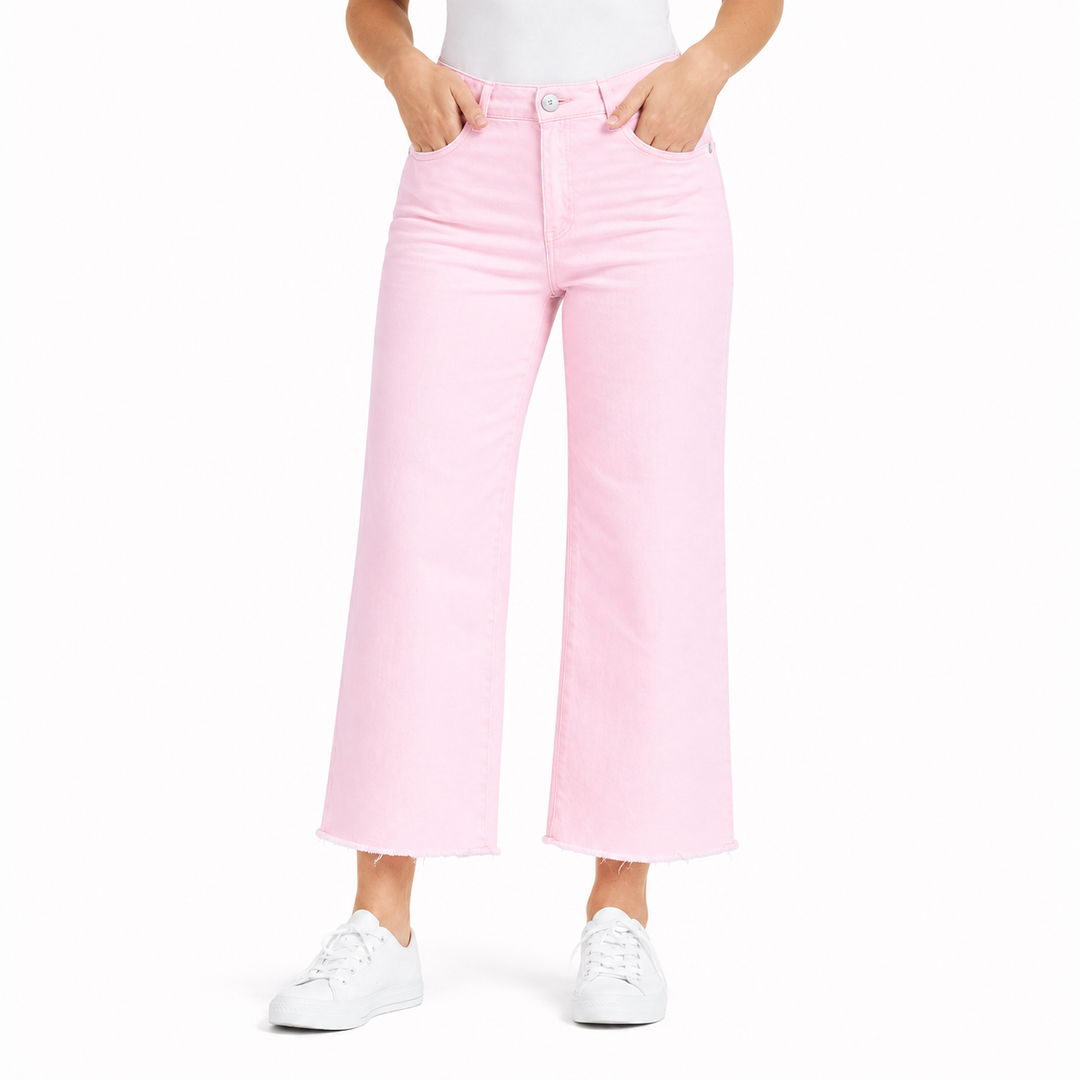 Person wearing light pink jeans and white sneakers on a white background