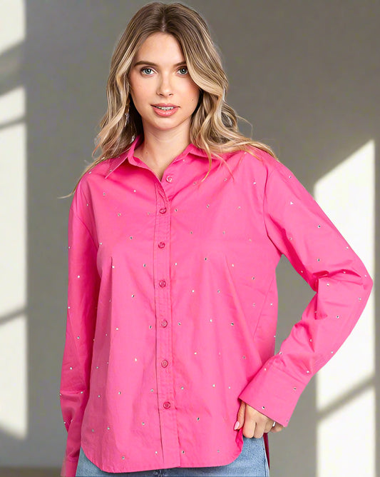 Woman wearing a bright pink shirt with a subtle pattern on a plain background