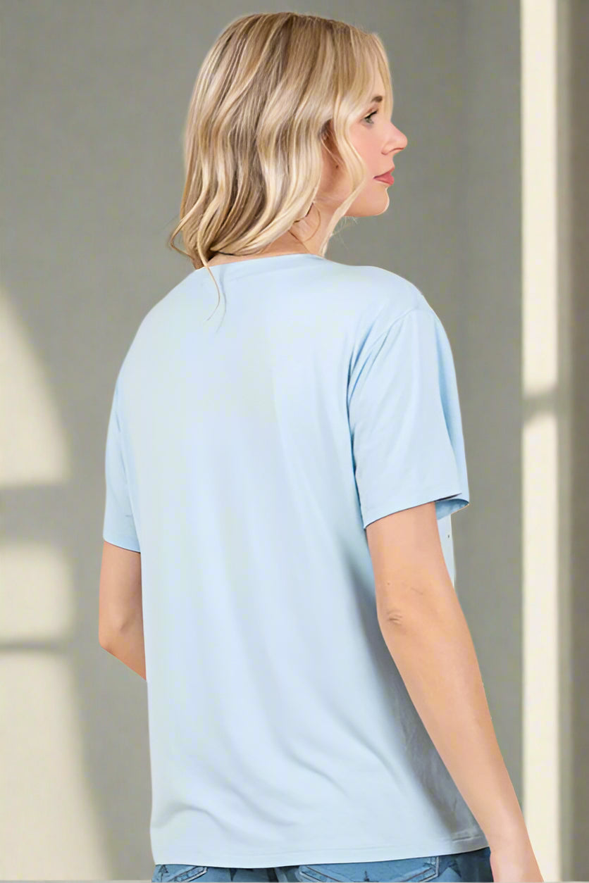Woman wearing a light blue t-shirt against a neutral background