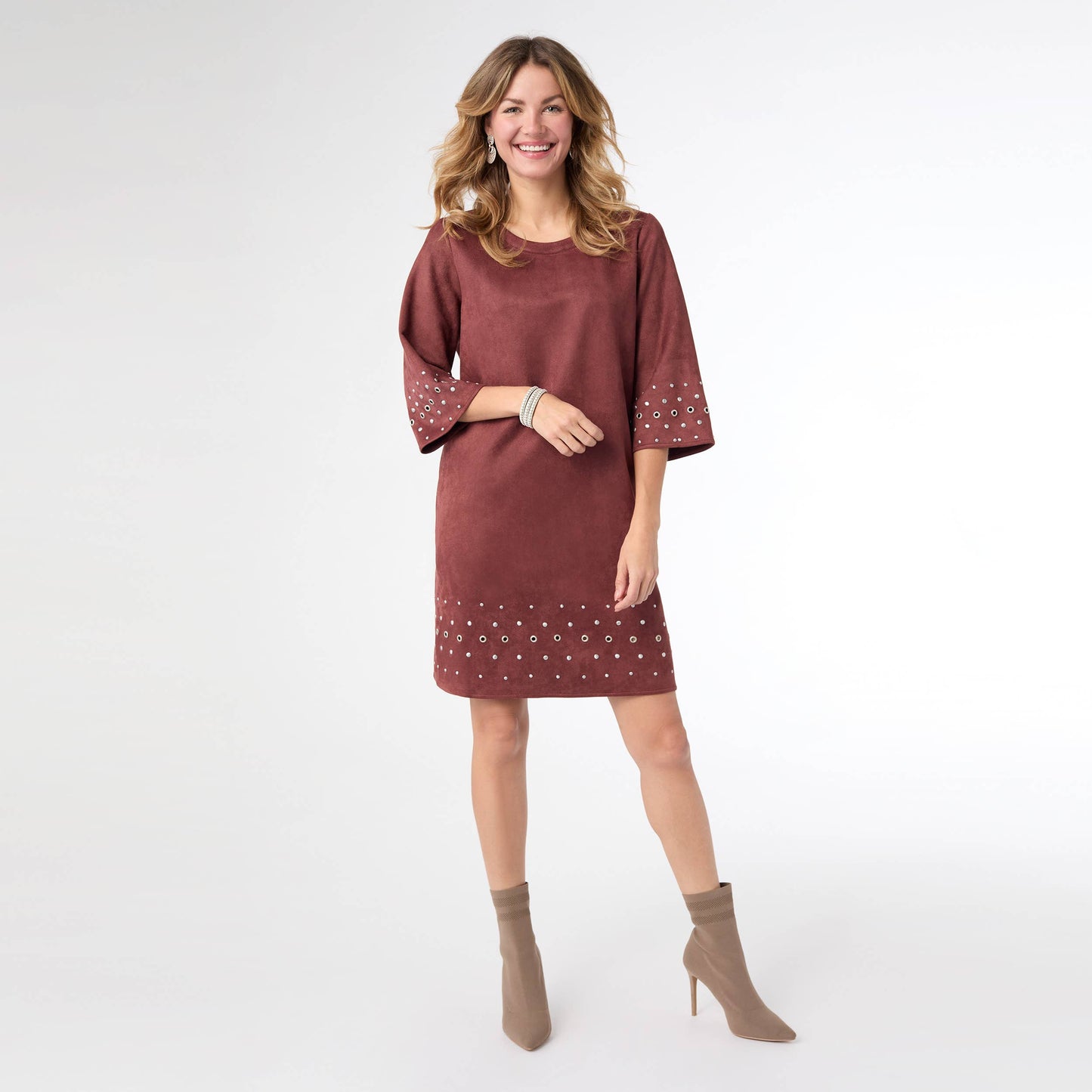 Woman wearing a maroon dress with white patterns on a white background