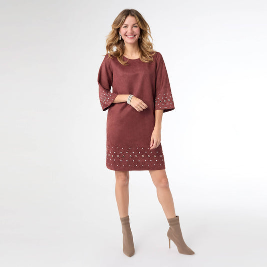 Woman wearing a maroon dress with white patterns on a white background