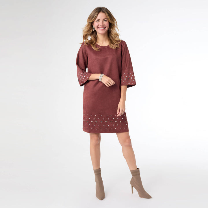 Woman wearing a maroon dress with white patterns on a white background