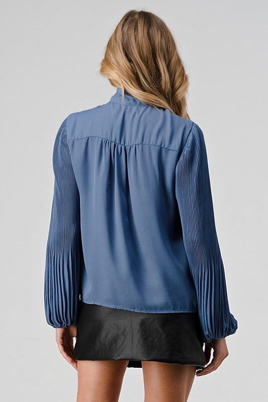 Person wearing a blue blouse and black skirt on a plain background
