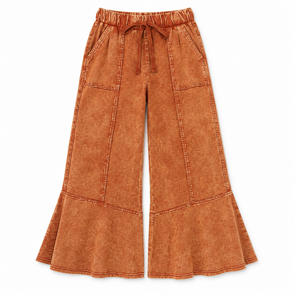 Wide-leg cropped pants in a rust-orange mineral-wash fabric, featuring an elastic waistband with a drawstring, side pockets, and a flared hem, shown against a plain white background.