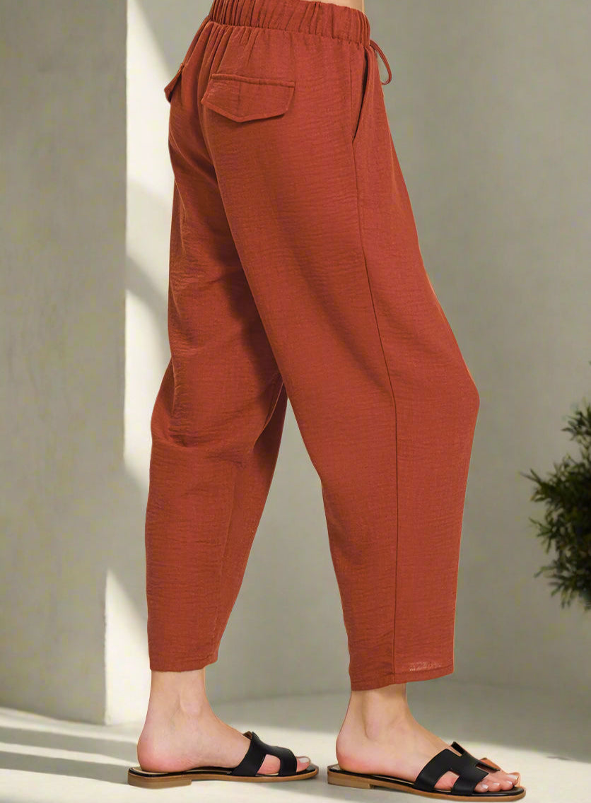 Brown pants worn by a person on a neutral background