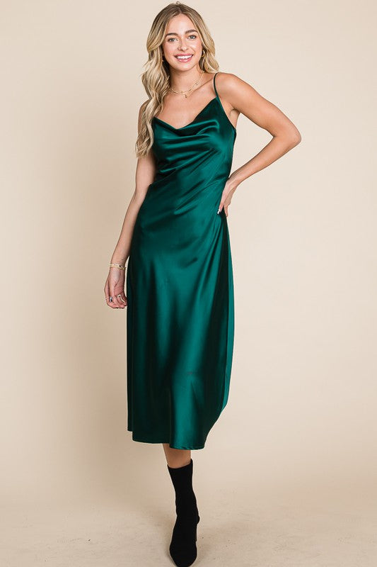 Woman wearing a green satin dress against a beige background