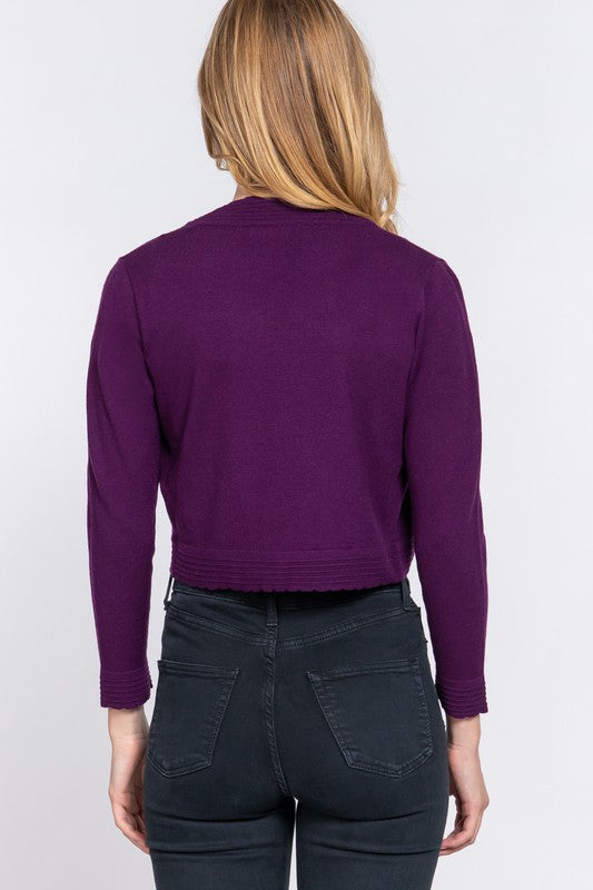 Person wearing a purple sweater and dark pants on a white background