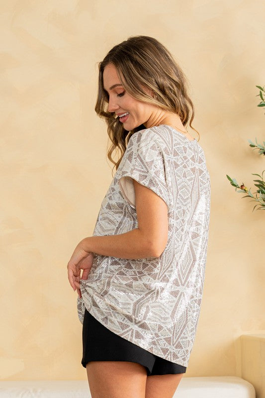 Woman wearing a white lace top against a beige wall