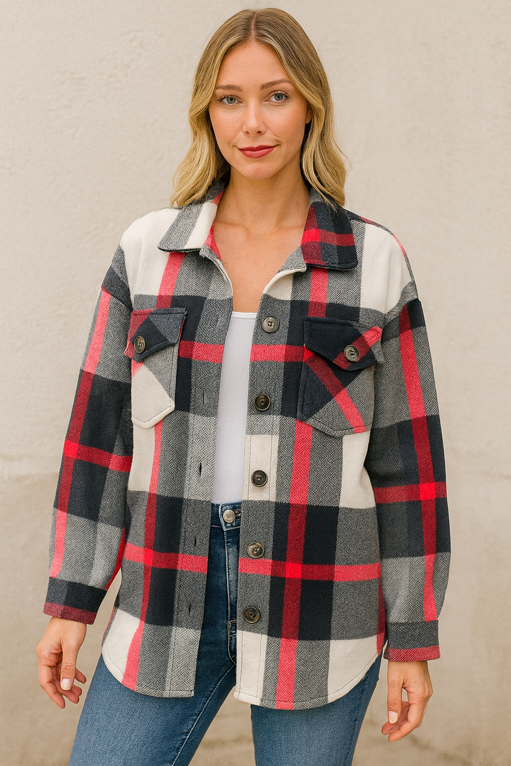 Woman wearing a plaid shirt with pink, black, and gray pattern on a neutral background