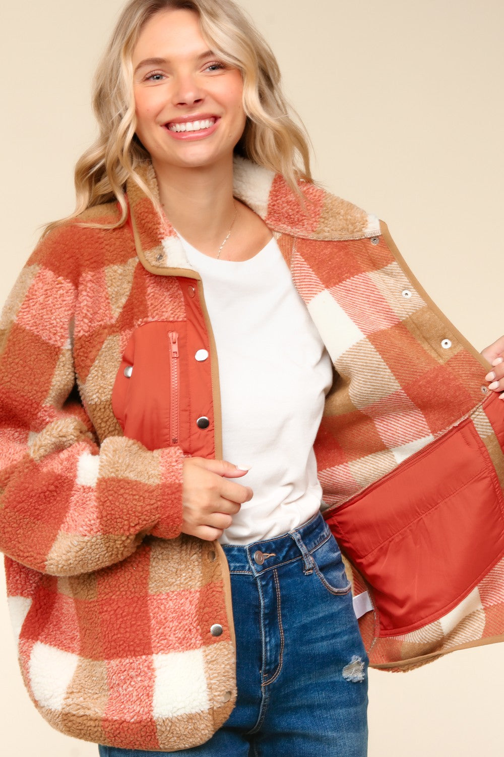 Woman wearing a plaid jacket with a neutral background