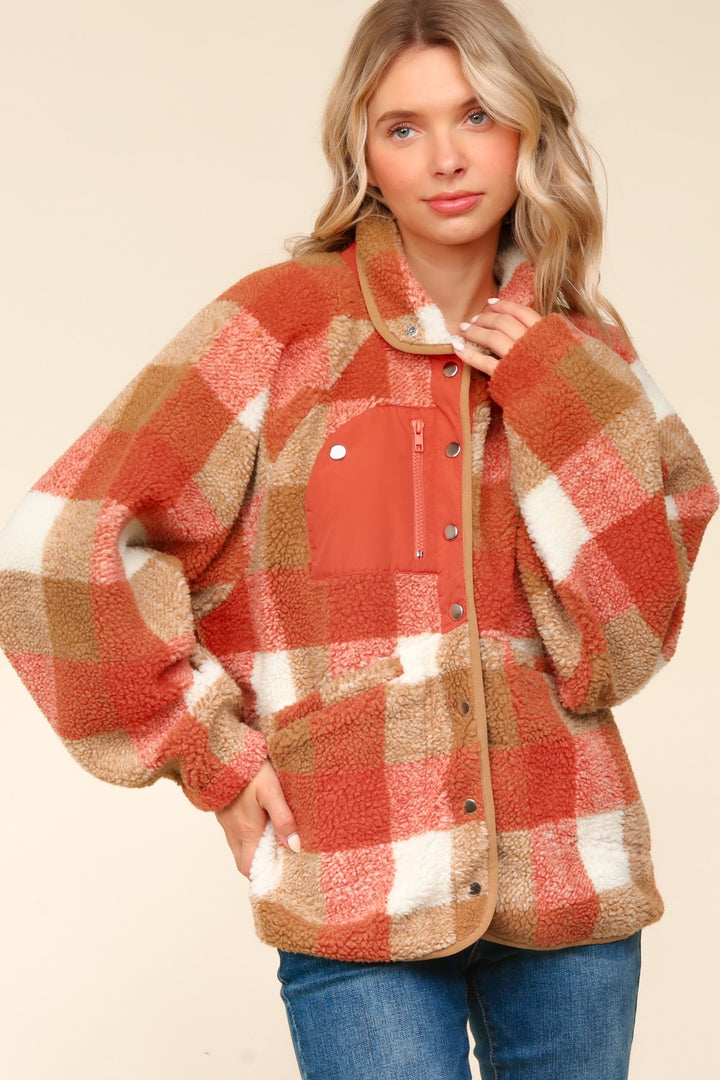 Woman wearing a red and brown plaid jacket on a beige background