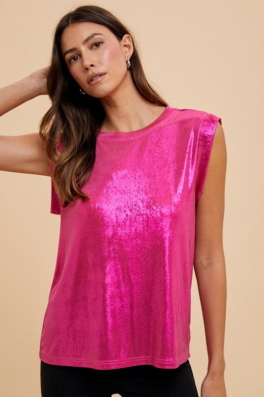 Woman wearing a bright pink metallic top against a beige background