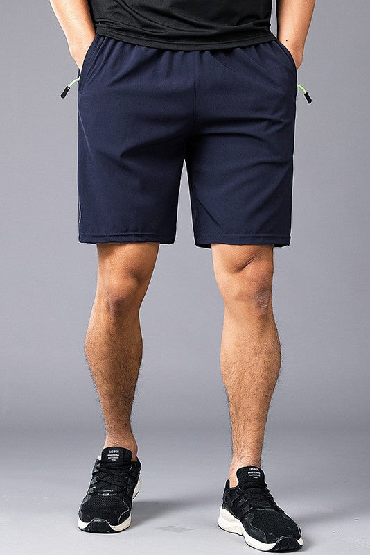 Person wearing navy shorts on a gray background