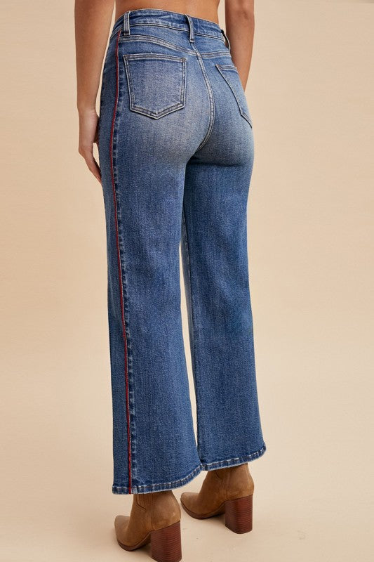 Blue jeans worn by a person on a beige background