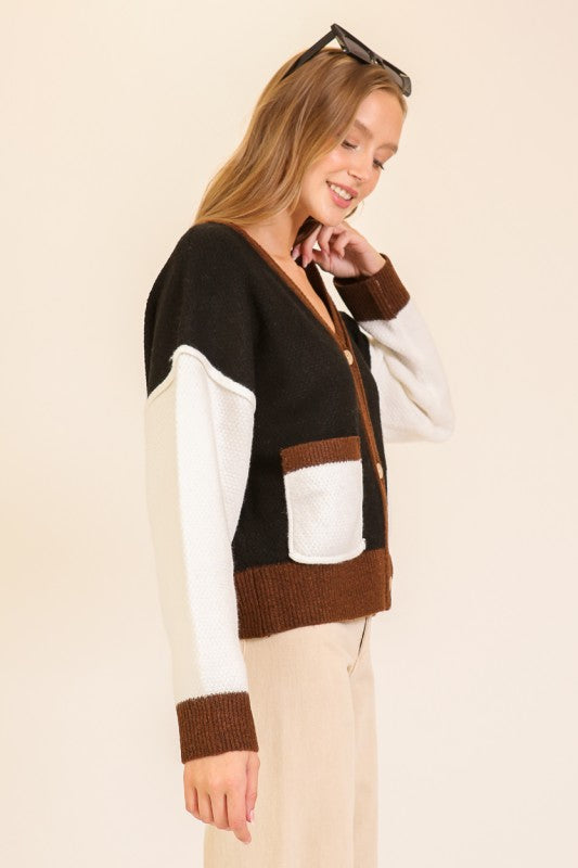 Person wearing a brown and white sweater with a neutral background