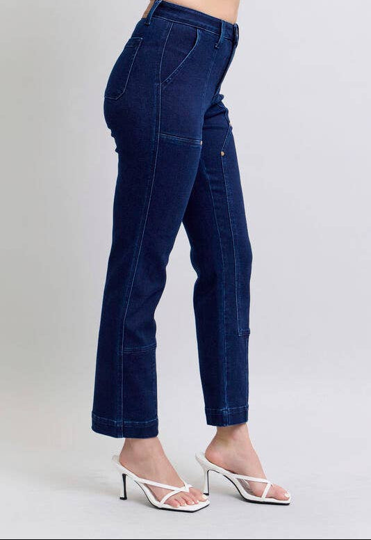 Dark blue jeans worn by a person on a light gray background