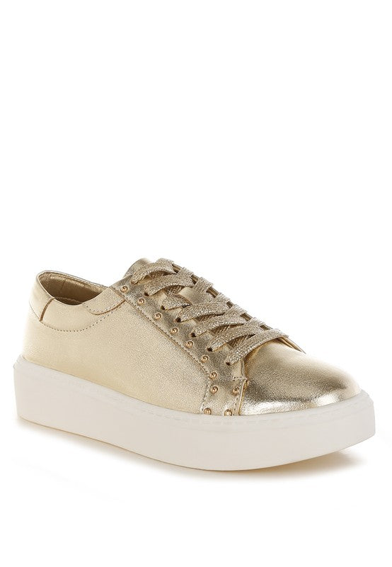 Gold sneaker with white sole on a white background