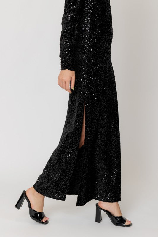 Black sequin dress with a slit on a white background