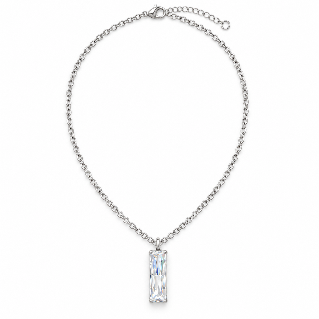 A silver chain necklace featuring a clear rectangular baguette-cut gemstone pendant, displayed against a solid white background.