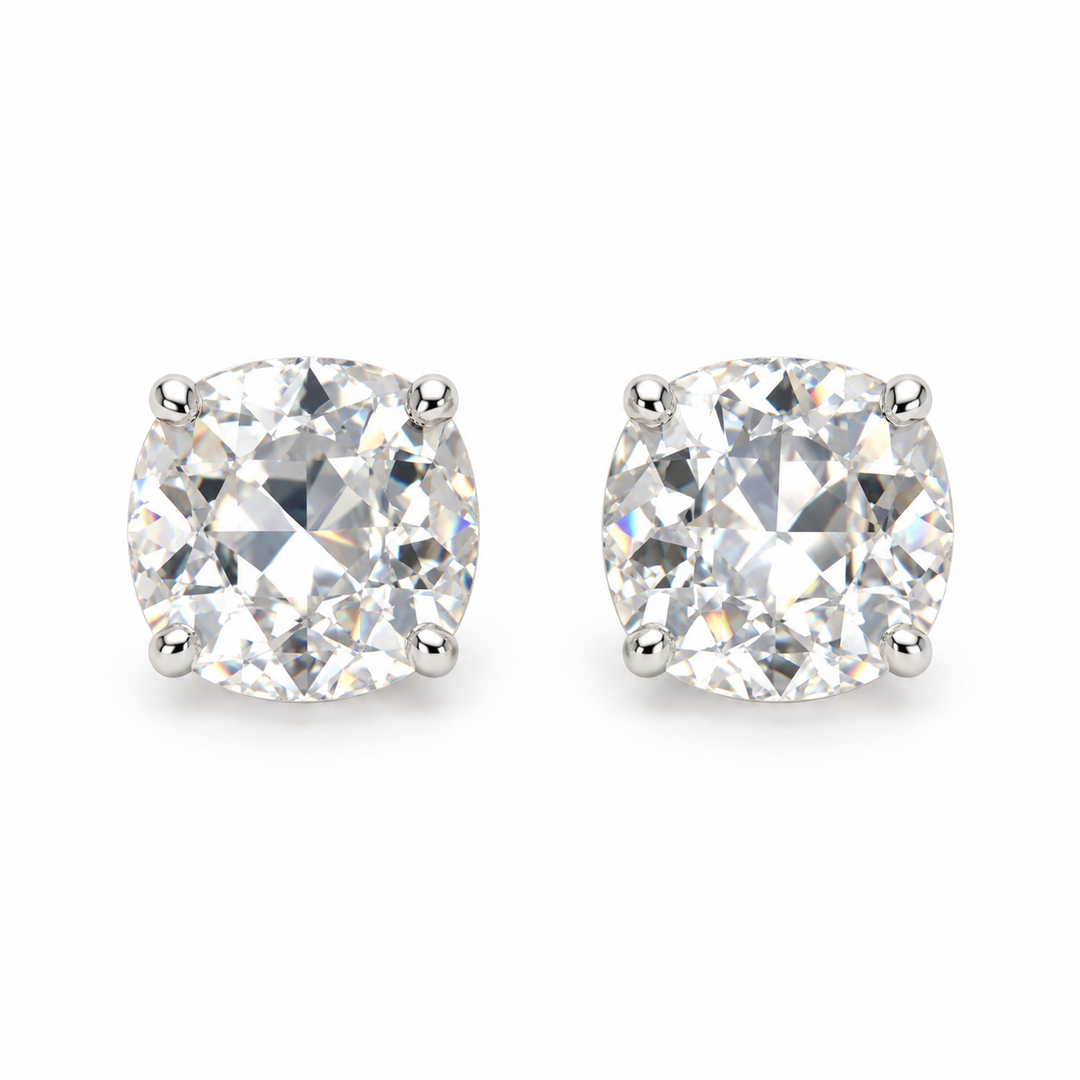 A pair of round brilliant-cut diamond stud earrings in a four-prong setting, displayed on a clean white background.