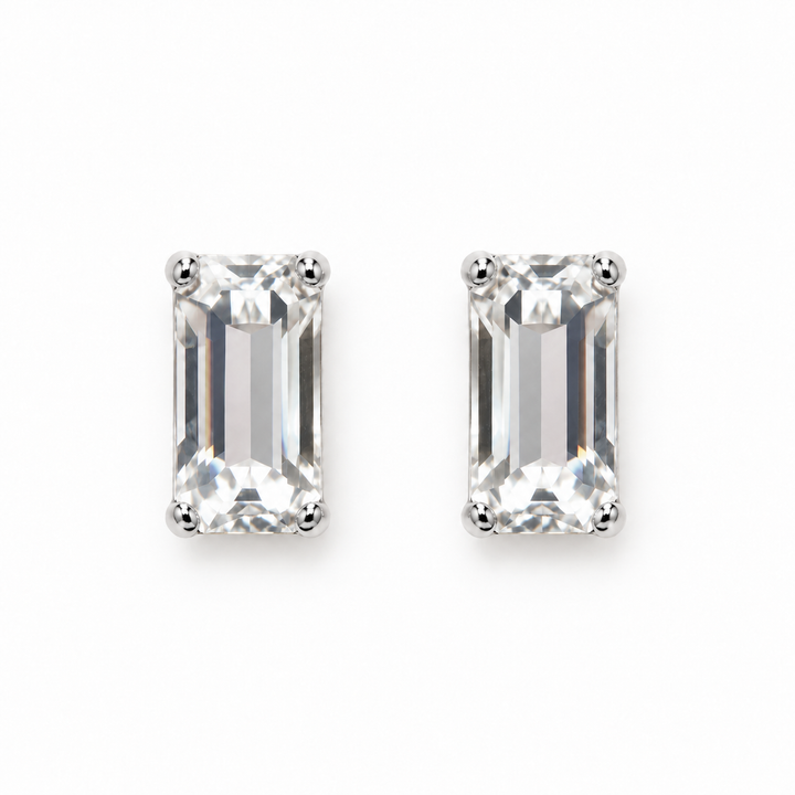 A pair of rectangular emerald-cut clear gemstone stud earrings set in silver-toned metal prongs, shown on a plain white background.