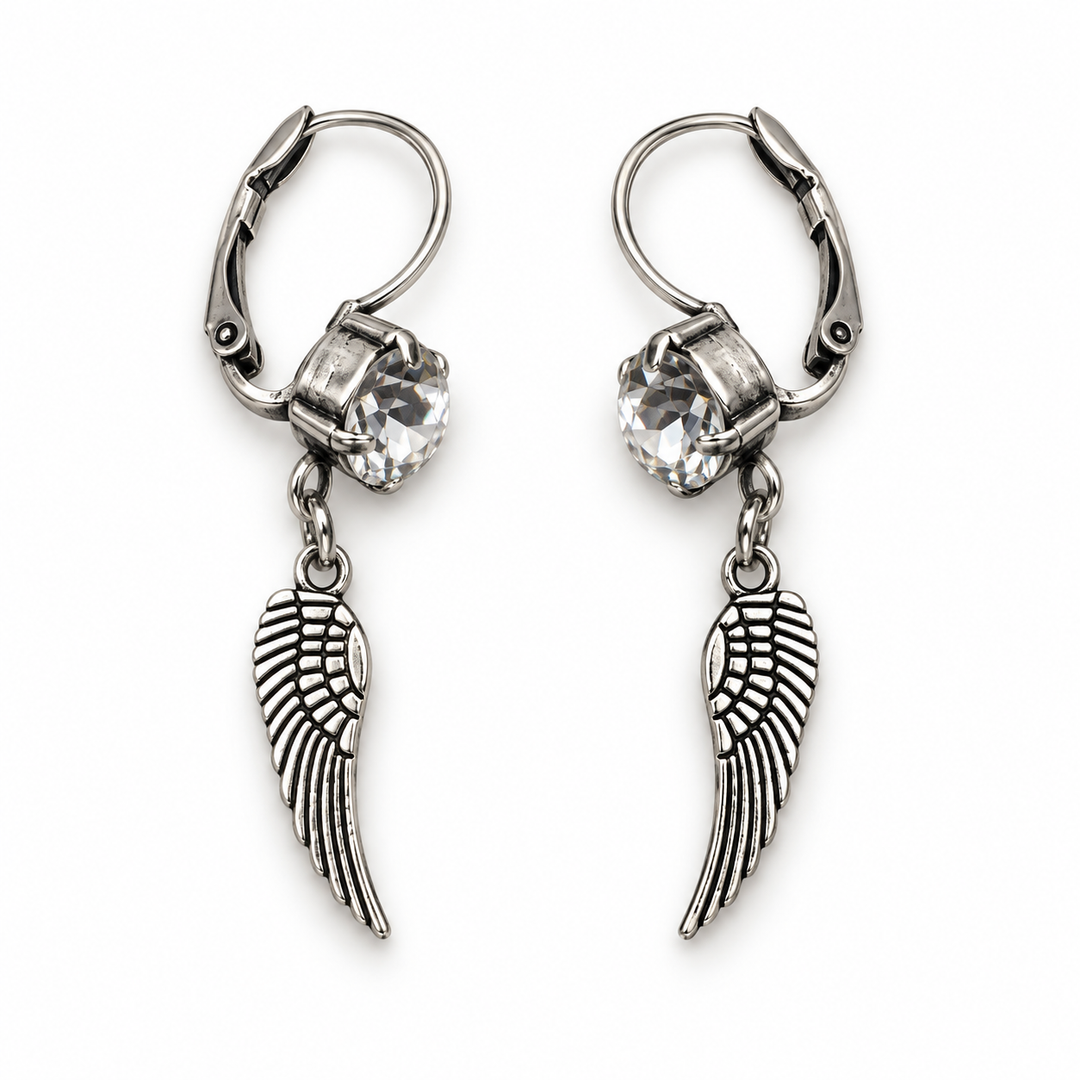 A pair of silver leverback earrings featuring a clear faceted crystal and a dangling wing charm, shown on a plain white background.