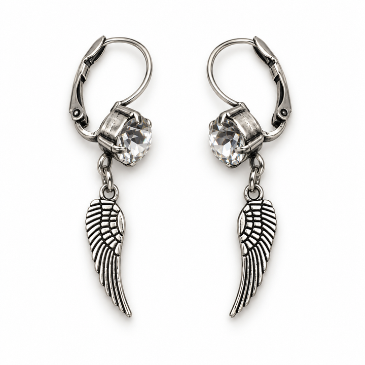 A pair of silver leverback earrings featuring a clear faceted crystal and a dangling wing charm, shown on a plain white background.
