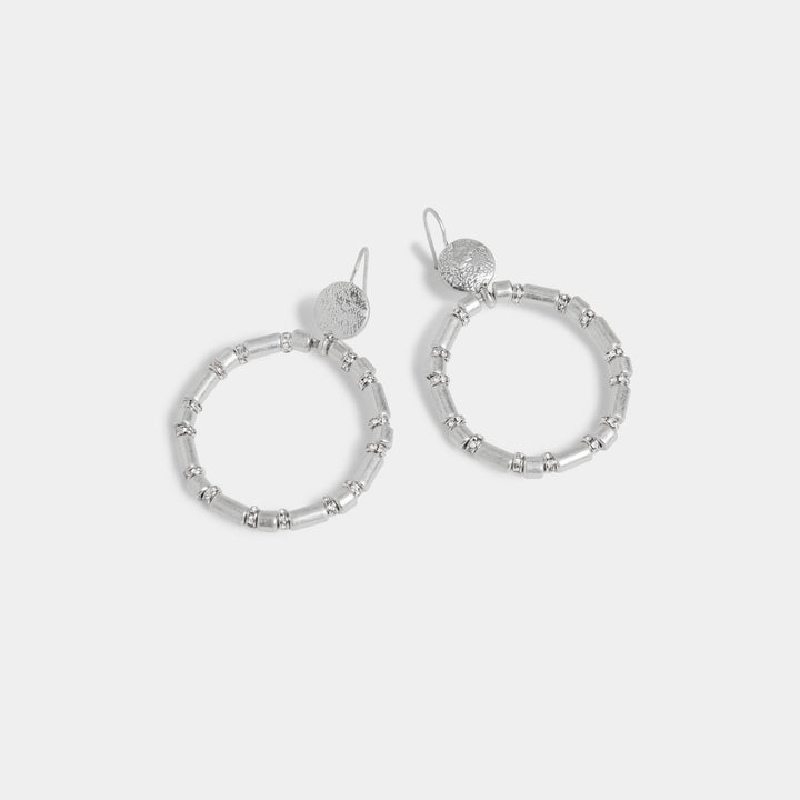 Silver hoop earrings on a light gray background