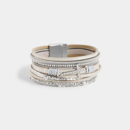 Multi-layered bracelet with metallic accents on a light gray background