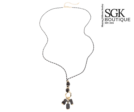 Necklace with black beads and gold accents on a white background, featuring SGK Boutique logo.