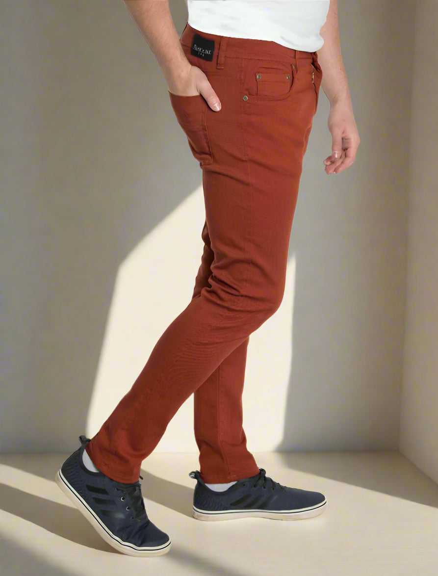 Person wearing rust-colored pants on a white background