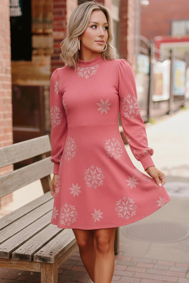 Woman wearing a pink dress with white floral patterns standing outdoors.