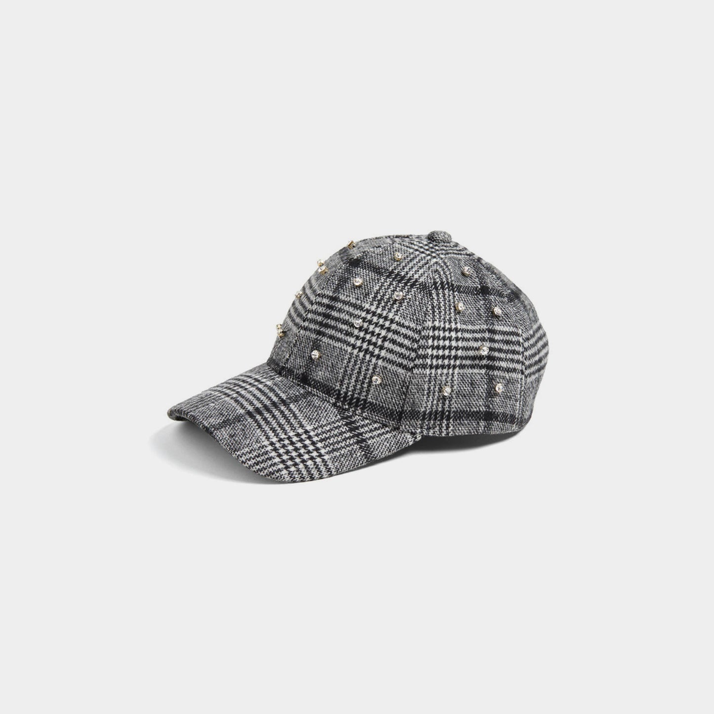 Plaid baseball cap with embellishments on a light gray background
