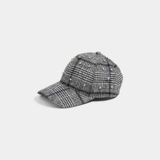 Plaid baseball cap with embellishments on a light gray background