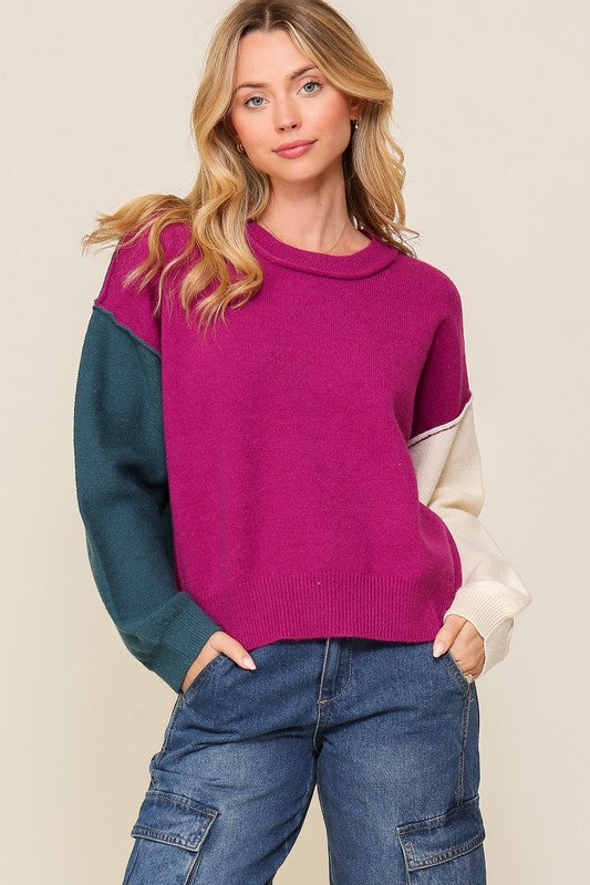 Woman wearing a colorful sweater with a plain background