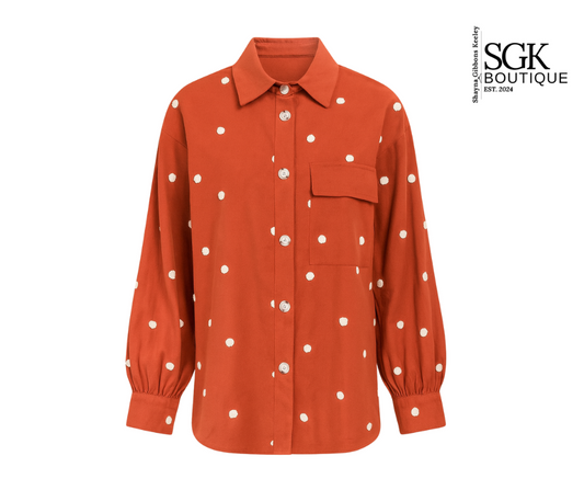 Orange shirt with white polka dots on a white background, featuring SGK Boutique logo.