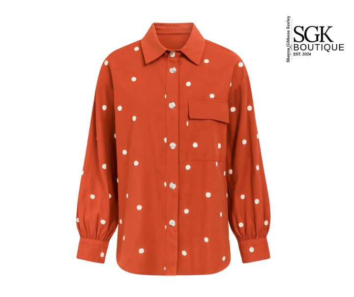Orange shirt with white polka dots on a white background, featuring SGK Boutique logo.