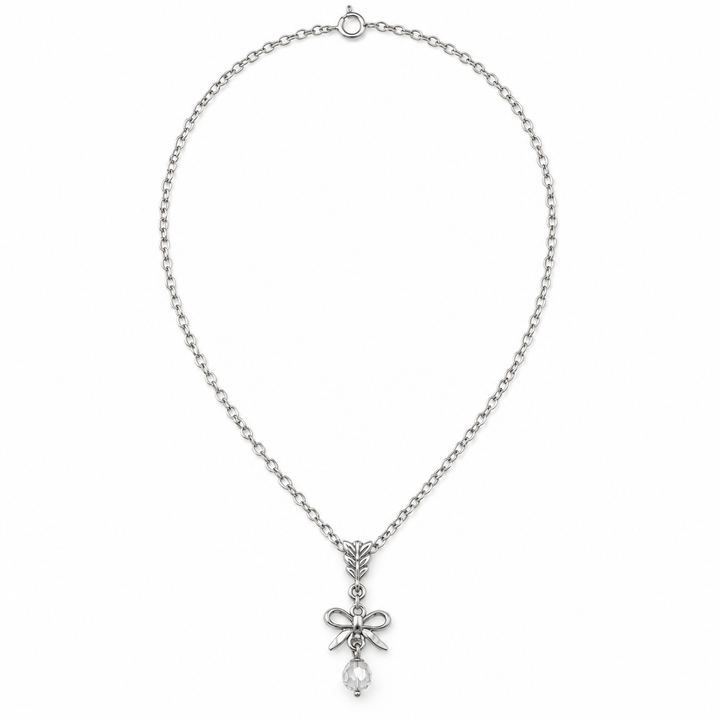A silver-toned chain necklace featuring a bow-shaped pendant with a clear teardrop crystal hanging from the center, displayed against a solid white background.