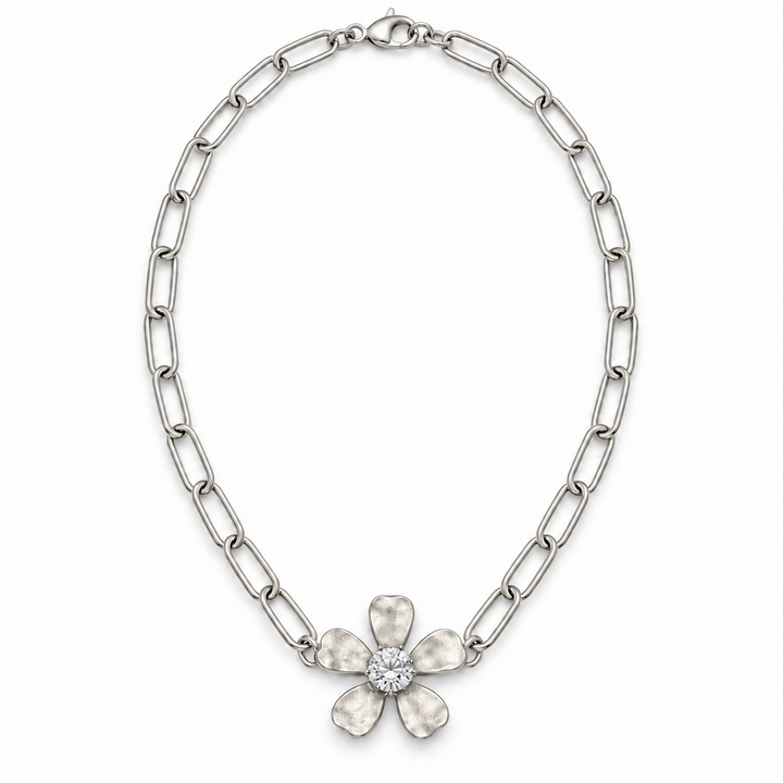 A silver-toned chain necklace featuring a flower-shaped pendant with five textured petals and a clear central stone, shown on a plain white background.