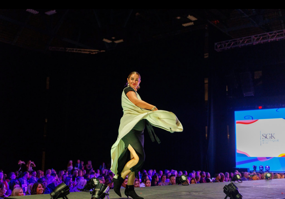 Model on stage with a large screen in the background at the Style of Hope 2025 Fashion Show.