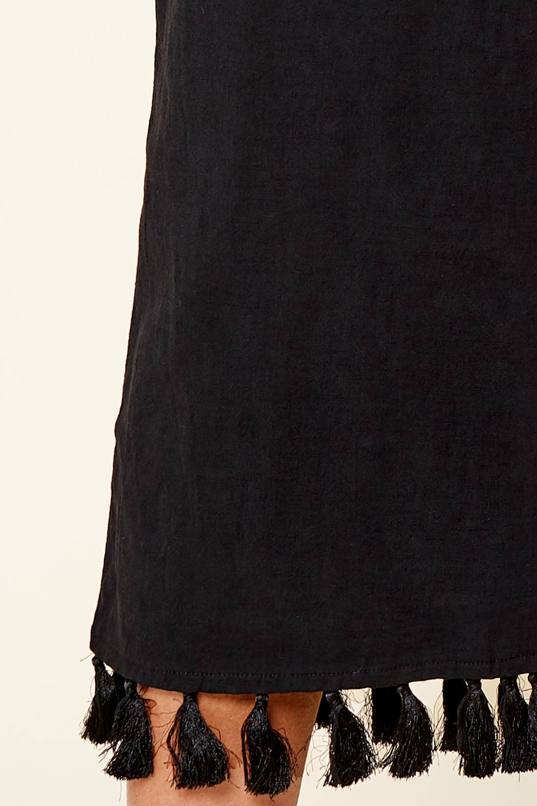 Black cropsVwith tassel details on a beige background