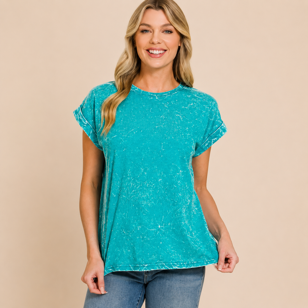 Woman wearing a teal t-shirt against a beige background