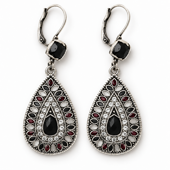 A pair of silver-toned teardrop dangle earrings with black bezel-set stones, red oval stones, and clear crystal accents, shown on a plain white background.
