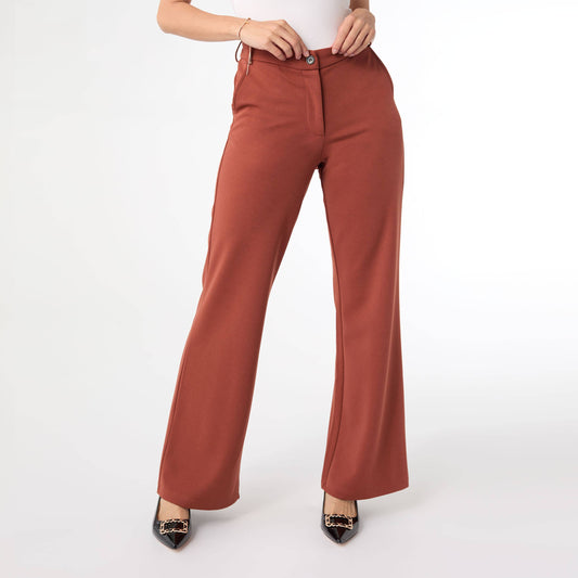 Terra cotta pants worn by a person on a white background
