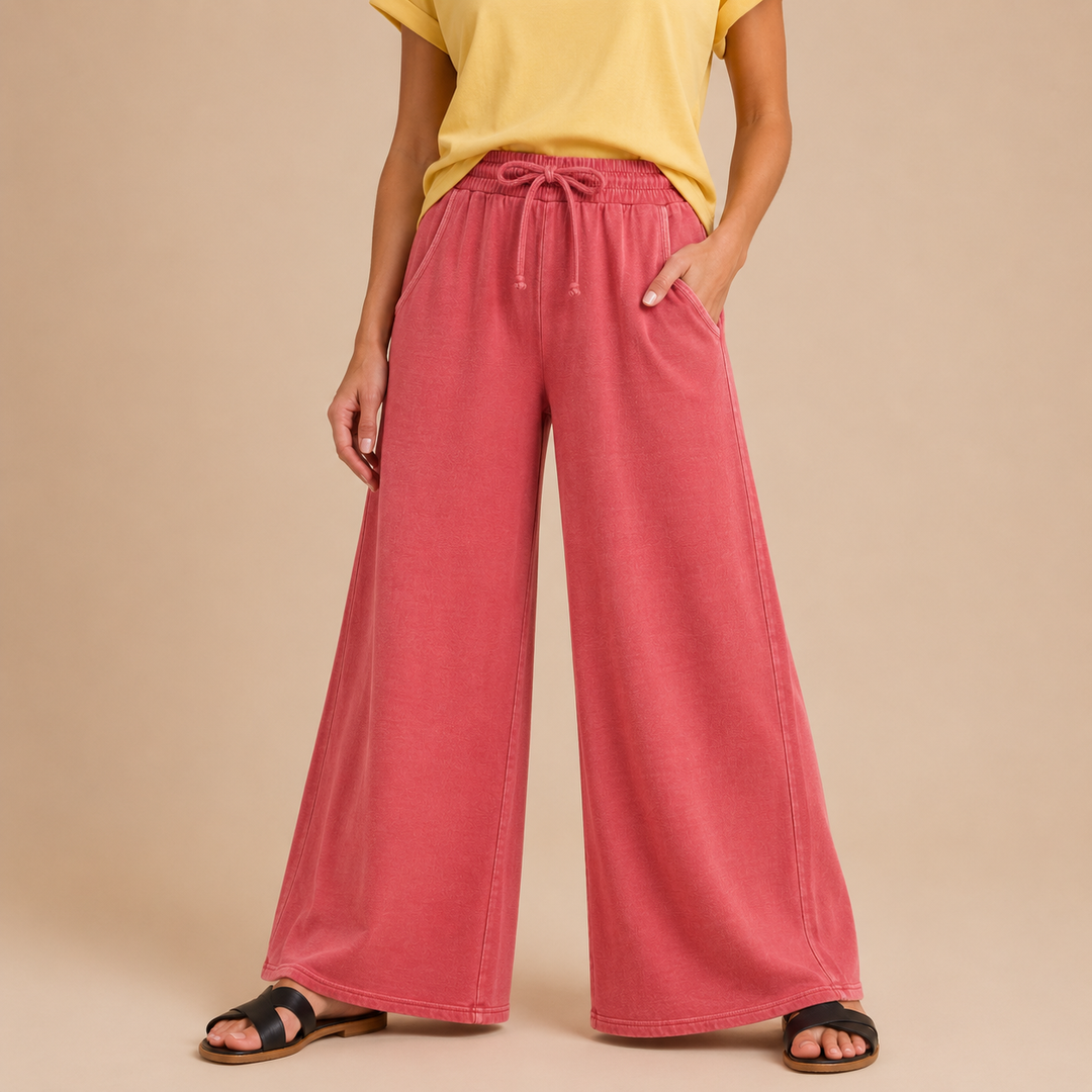 Person wearing heather-red wide-leg pants and a yellow top on a beige background