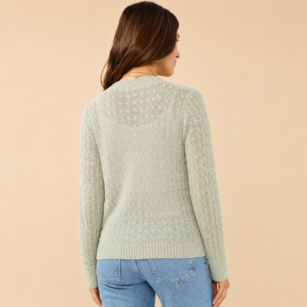 Woman wearing a light green sweater with a subtle pattern on a beige background