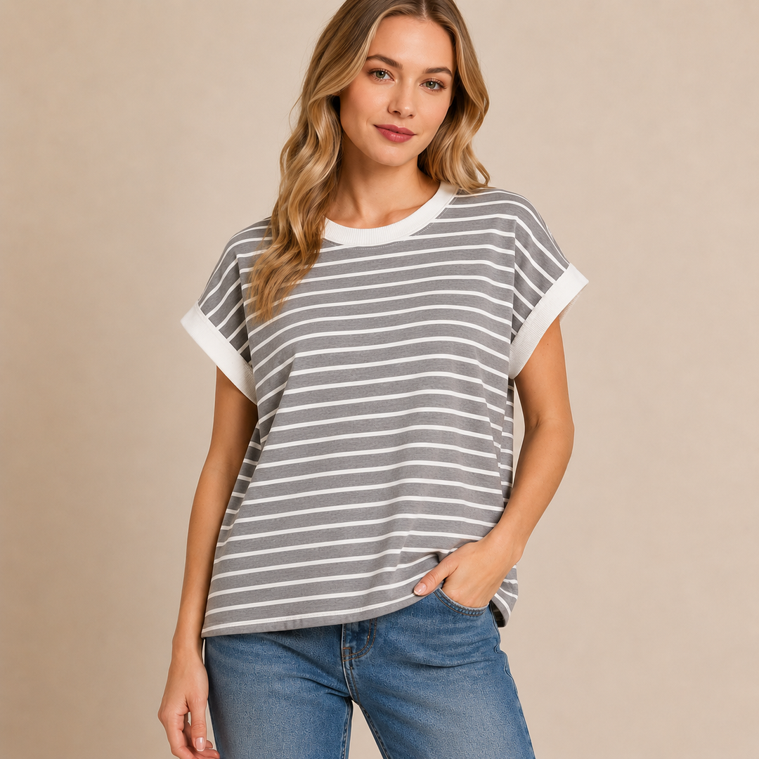 Woman wearing a gray and white striped t-shirt with blue jeans on a beige background