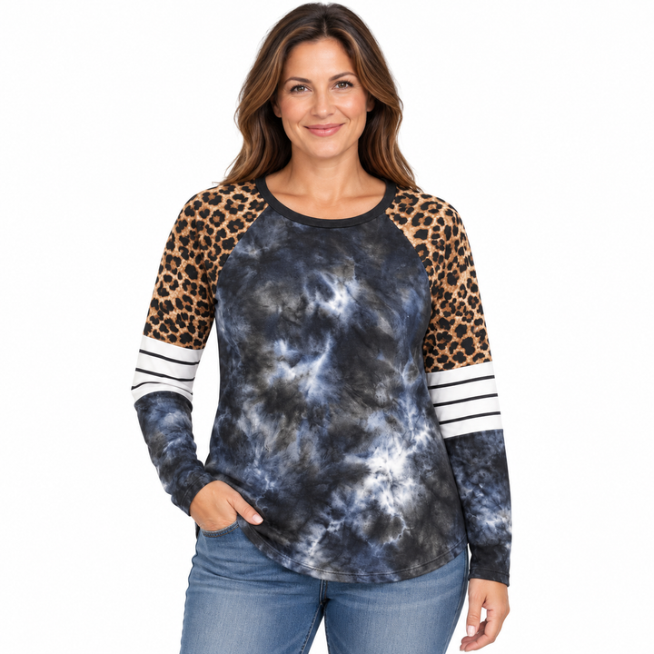 A woman modeling a long-sleeve raglan top with a blue and gray tie-dye body, leopard print sleeves, and white stripes on the cuffs, paired with blue jeans against a plain white background.